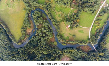Aerial view of river bend through forest.