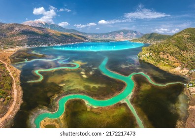 Aerial View Of River Delta, Boats And Yachts In Blue Lagoon, Mountains And Sky At Sunset. Summer In Lefkada Island, Greece. Top View Of River Estuary, Sea Bay, Sailboats, Rocks, Green Forest. Colorful