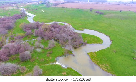 Aerial view of river flowing through vacant farmland in Nanticoke, Ontario.