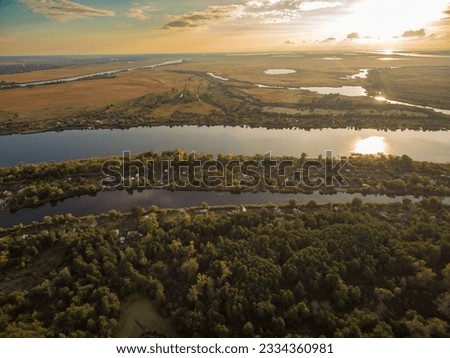 Aerial view of the river, forest and fields in the light of the rising sun. Kherson region, Kherson, Ukraine.