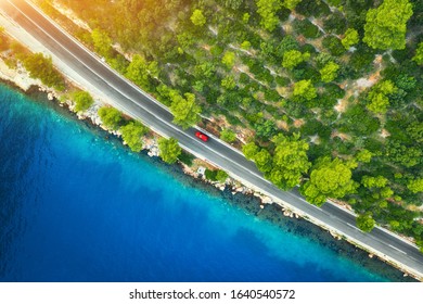 Aerial View Of Road In Beautiful Green Forest And Sea Coast At Sunset In Spring. Colorful Landscape With Cars On Roadway, Blue Water, Trees In Summer. Top View From Drone Of Highway In Croatia. Travel