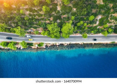 Aerial View Of Road In Beautiful Green Forest And Sea Coast At Sunset In Spring. Colorful Landscape With Cars On Roadway, Blue Water, Trees In Summer. Top View From Drone Of Highway In Croatia. Travel