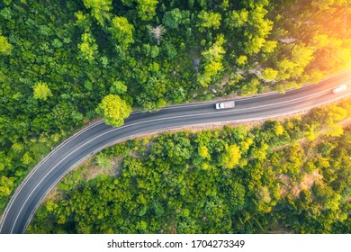 Aerial View Of Road In Beautiful Green Forest At Sunset In Spring. Colorful Landscape With Car On The Roadway, Trees In Summer. Top View From Drone Of Highway In Croatia. View From Above. Travel