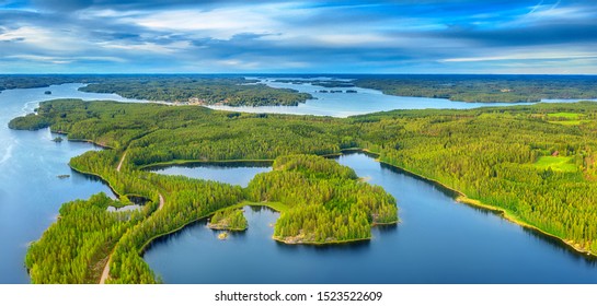 Aerial View Of Road Between Green Summer Forest And Blue Lake In Finland