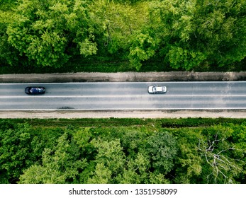 Aerial View Of Road With Cars Going Through Green Spring Forest.