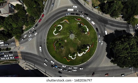 Aerial view of a road circle with grass in the center. Roundabout from the air