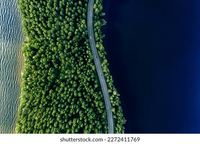 Aerial view of road in green woods and blue lakes water in summer Finland - Powered by Shutterstock