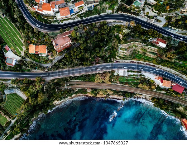 Aerial view of\
road, highway and railway going along ocean or sea. Drone\
photography from above in rural\
Italy