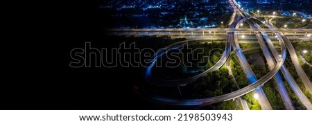 Aerial view of road interchange or highway intersection of Expressway top view, Road traffic an important infrastructure, car traffic transportation above intersection road in city night.