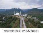 Aerial view of road leading to Faisal Mosque Islamabad Pakistan surrounded by green Margala hills.