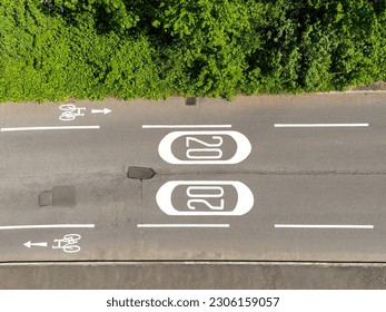 Aerial view of road markings for a 20 mph speed limit zone and cycle lanes. No people.