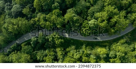Aerial view of a road in the middle of the forest , road curve construction up to mountain	