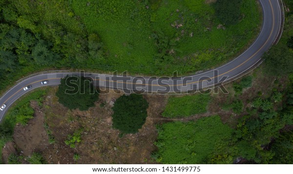 Aerial view road in mountains, Road running\
through green hills forest with\
car.