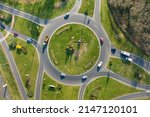 Aerial view of road roundabout intersection with moving heavy traffic. Urban circular transportation crossroads