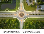 Aerial view of road roundabout intersection with moving cars traffic. Rural circular transportation crossroads