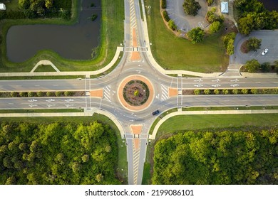 Aerial view of road roundabout intersection with moving cars traffic. Rural circular transportation crossroads