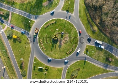 Aerial view of road roundabout intersection with moving heavy traffic. Urban circular transportation crossroads