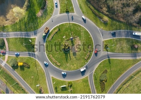Aerial view of road roundabout intersection with moving heavy traffic. Urban circular transportation crossroads