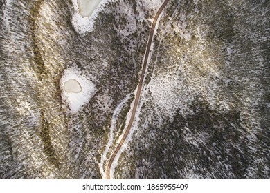 Aerial View Of The Road And Taiga Forest In Winter On A Sunny Bright Day. Abstract Landscape Of Northern Nature With Drone. Local Map