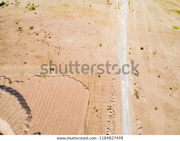 Aerial view of road with. Aerial\
view of a country road with sand. Car passing by. Aerial\
construction road. Aerial view flying. Captured from above with a\
drone.