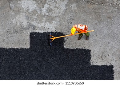 Aerial View Of Road Worker Repair Asphalt Covering. Contrast Between New And Old Road Surface