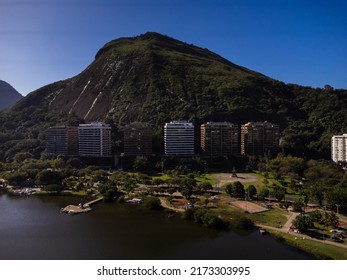 Aerial View Of Rodrigo De Freitas Lagoon, South Zone Of Rio De Janeiro, Brazil. In The Background, The Beaches Of Ipanema And Leblon. Sunny Day. Cars Traveling On Avenida Epitácio Pessoa. Drone Photo.