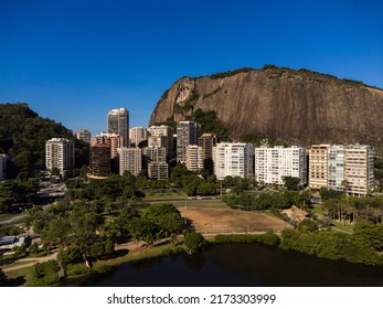 Aerial View Of Rodrigo De Freitas Lagoon, South Zone Of Rio De Janeiro, Brazil. In The Background, The Beaches Of Ipanema And Leblon. Sunny Day. Cars Traveling On Avenida Epitácio Pessoa. Drone Photo.