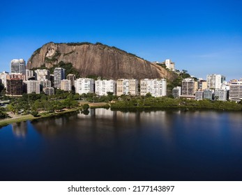 Aerial View Of Rodrigo De Freitas Lagoon, South Zone Of Rio De Janeiro, Brazil. In The Background, The Beaches Of Ipanema And Leblon. Sunny Day. Cars Traveling On Avenida Epitácio Pessoa. Drone Photo.