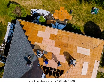 Aerial View Of Roof Construction Repairman On A Residential Apartment With New Roof Shingle Being Applied