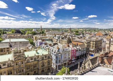 Aerial view of roofs and spires of Oxford, England with blue sky in background