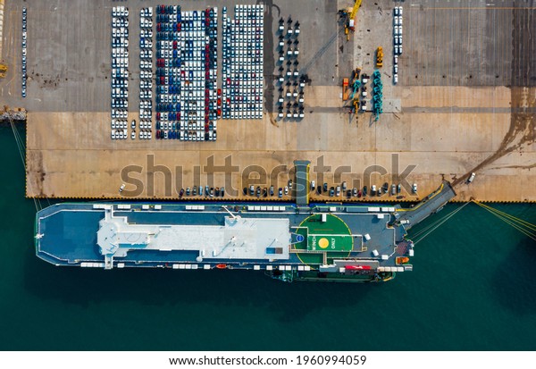 Aerial view Ro-Ro Ship\
of business logistic sea freight, New Cars produced by year up in\
the port for Cargo ship and Cargo import-export around in the\
world. cargo ship 