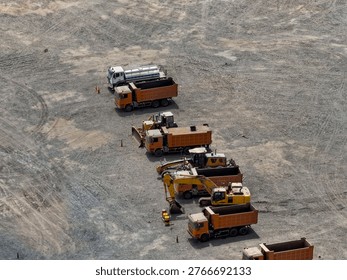 Aerial view of row of mining dump trucks waiting for shift change