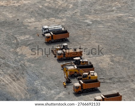Aerial view of row of mining dump trucks waiting for shift change