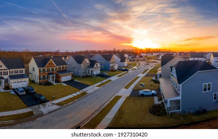 Aerial view of a row of multi story single family homes real estate properties in a new residential suburban neighborhood street in Maryland USA with dramatic colorful sunset sky - Shutterstock ID 1927310420