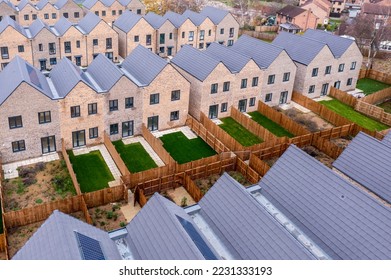 Aerial view of rows of new build modular terraced houses in the UK with characterless design for first time buyers