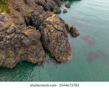 Aerial view of the rugged cliffs and pristine waters along the coastline of Vancouver Island, BC, Canada. The natural beauty of the rocky landscape and clear ocean is captivating. - Powered by Shutterstock