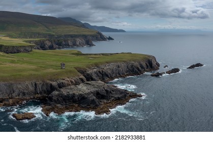 Aerial View Of The Rugged Coastline Of County Donegal At Malin Beg With The Ruins Of The Napoleonic Signal Tower On The Cliff Edge