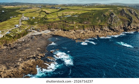 Aerial view of a rugged coastline with rocky shores and crashing waves. At Cape Cornwall, UK. - Powered by Shutterstock