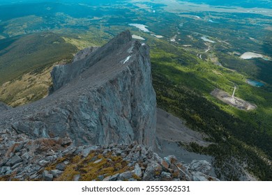 Aerial view of a rugged mountain peak with steep cliffs, surrounded by lush green valleys and winding rivers. landscape features a mix of rocky terrain and forested areas, showcasing the beauty  - Powered by Shutterstock