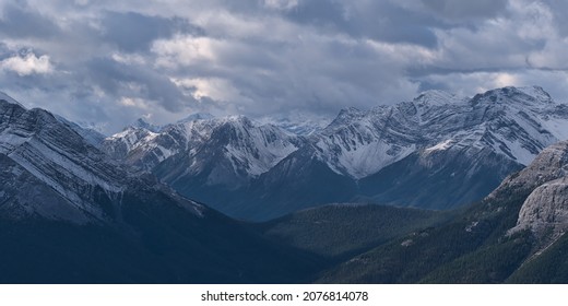 Aerial view of rugged Sundance Range in the Rocky Mountains near Canmore, Alberta, Canada with snow-capped Mount Turbulent viewed from Ha Ling Peak in autumn with cloudy sky. - Shutterstock ID 2076814078