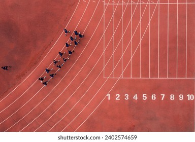 An aerial view of a running track with a group of runners. - Powered by Shutterstock