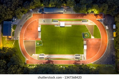 Aerial View Of Running Track Where Athletics Are Training At Night Under Bright Stadium Lights