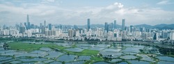 Aerial View Of Rural Green Fields With Fish Ponds On Hong Kong And The Skylines Of Shenzhen