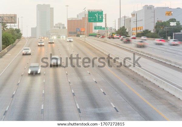 Aerial view rush hour traffic in downtown Houston,\
Texas, America. Long exposure slow motion many cars commute on\
interstate highway at late afternoon with light trail,\
high-occupancy vehicle\
lane