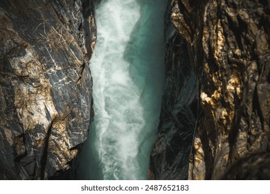 Aerial view of rushing water flowing through a narrow, rocky gorge. - Powered by Shutterstock