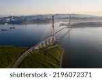 Aerial view of the Russian bridge from the mainland to the Russian island in the East Sea. The longest longest span. Summer dawn on the sea. Guys in the colors of the Russian flag. Vladivostok