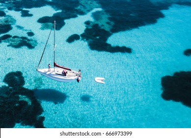 Aerial View Of A Sail Boat In Front Of Mortorio Island In Sardinia. Amazing Beach With A Turquoise And Transparent Sea. Emerald Coast, Sardinia, Italy.
