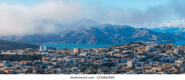 Aerial view of San Francisco with the Golden Gate Bridge in mist, dense urban cityscape, and Marin County hills in the background. - Powered by Shutterstock