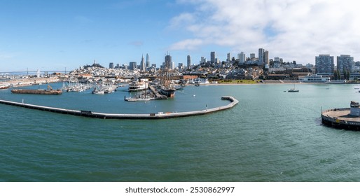 Aerial view of San Francisco's skyline featuring the Transamerica Pyramid, waterfront docks, and the Golden Gate Bridge in the distance under a clear sky. - Powered by Shutterstock