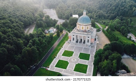 Aerial View Of The Sanctuary Of Oropa, Roman Catholic Building In The Biellese Alps, Northern Italy. Tourist Attraction And Famous Place Of Pilgrimage In Piedmont. Drone Photography.